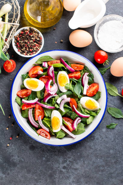istock Spring salad. Salad with spinach leaves, tomatoes and boiled egg. Proper nutrition. The taste of summer. Raw ingredients in a snack. Seasonal vegetables and herbs. Healthy snack 1320497169