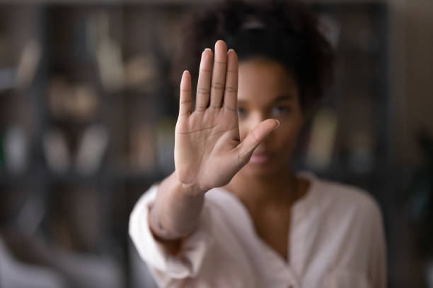 mulher afro-americana séria protestando contra o bullying. - road sign symbol stop stop gesture - fotografias e filmes do acervo