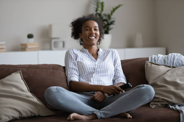 istock Happy african american woman watching funny smart TV programs. 1320498065