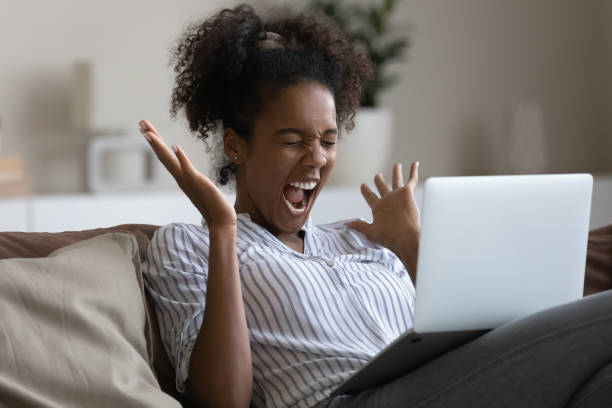 istock Overjoyed young african american woman celebrating online win. 1320498113