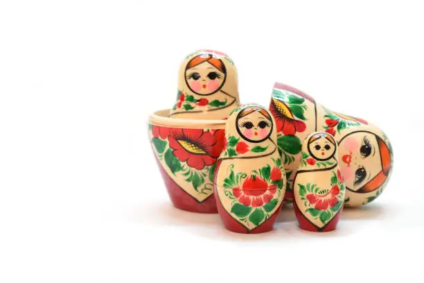 One large disassembled nesting doll and several assembled. Isolated on a white backdrop.