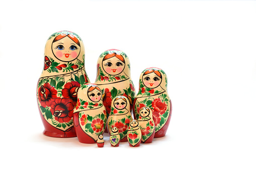 A set of nesting dolls lined up in three rows in front of each other. Isolated on a white background.