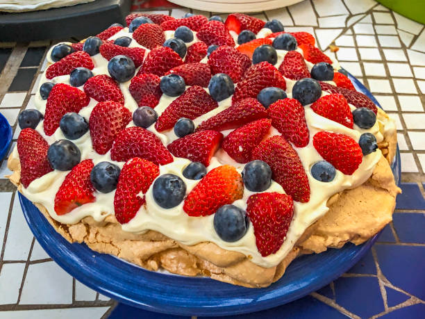 Strawberry pavlova with blueberries & cream on a blue plate