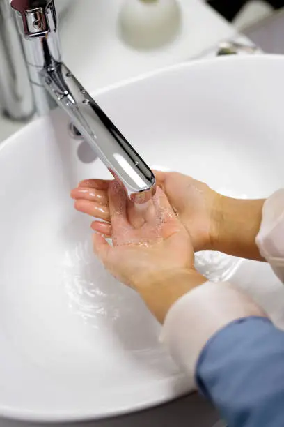 A person washing hands in bathroom