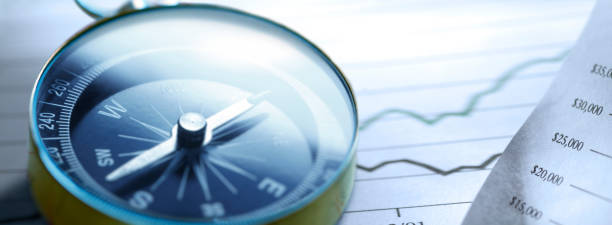 istock Compass Resting On A Stock Market Chart 1320504018