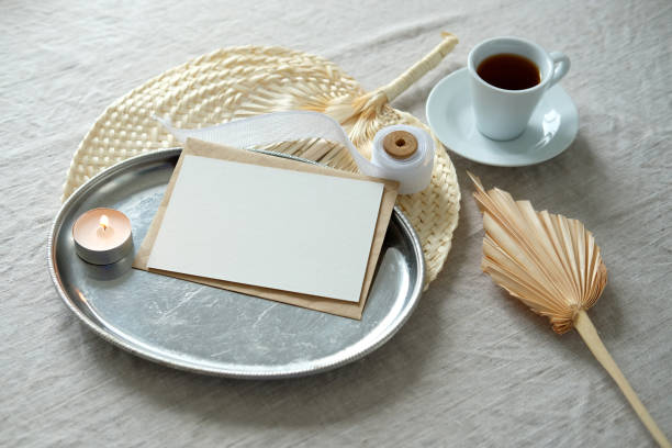 istock Wedding composition with paper card invitation mockup, candle, ribbon, boho style decorations, cup of coffee on linine tablecloth. 1320504160