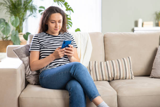 istock Young woman using phone at home 1320506754