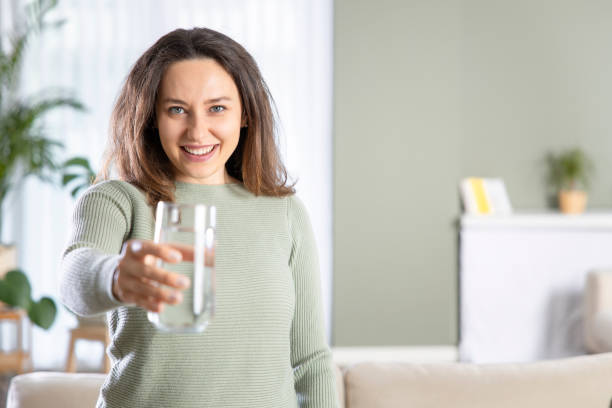 istock Woman drinking water at home 1320506863