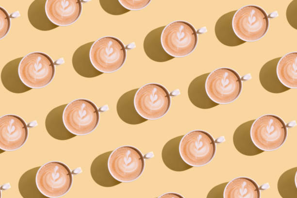 istock Pattern of ceramic cup with cappuccino and heart decoration on foam with hard shadow on colored background 1320508054