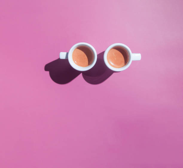 istock Two cups of coffee espresso top view with hard shadows on colored background 1320508058
