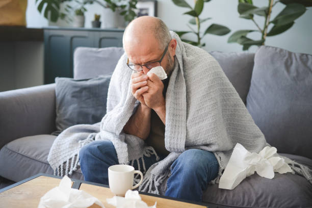 istock sick man sitting on a sofa in the room 1320508198