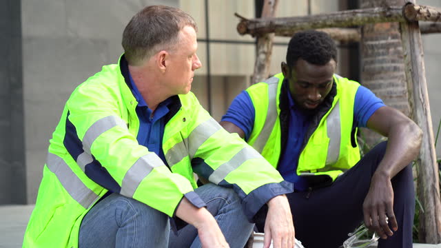 Unhappy African american technician and senior engineer manager Take a break sitting on street talking together having problems in work . Fired from work . worker man stress from unemployed