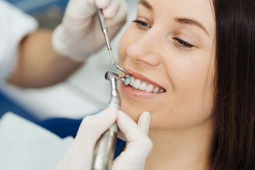 Higiene oral, dentista haciendo procedimiento de raspado y cepillado photo