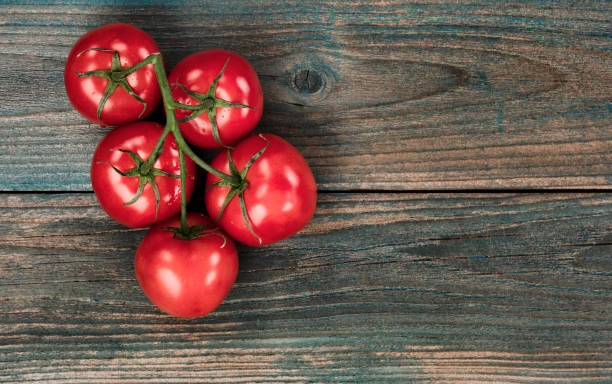 istock Top view of fresh tomatoes on faded blue rustic wood table 1320512186