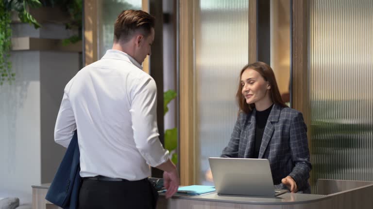 Business man arrive to hotel check in ot check out pay by credit card and Ask for information to receptionist woman registration at reception counter