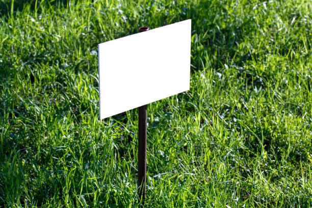 istock blank white sign mockup on green lawn background - close-up with selective focus 1320514333