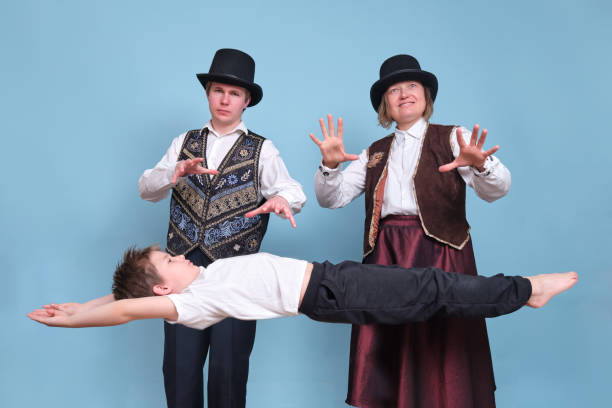 istock Magicians levitated a boy in the air, circus performers on a blue background 1320517936