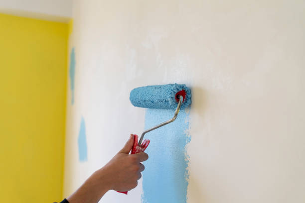istock Workman painting the wall in blue. 1320517999