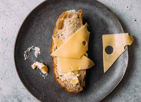 Swiss cheese and bread on a dark gray ceramic plate