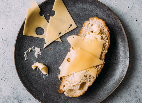 Swiss cheese and bread on a dark gray ceramic plate