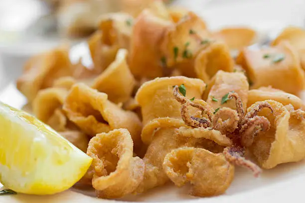 Traditional Italian style fried calamari with a wedge of lemon on the side