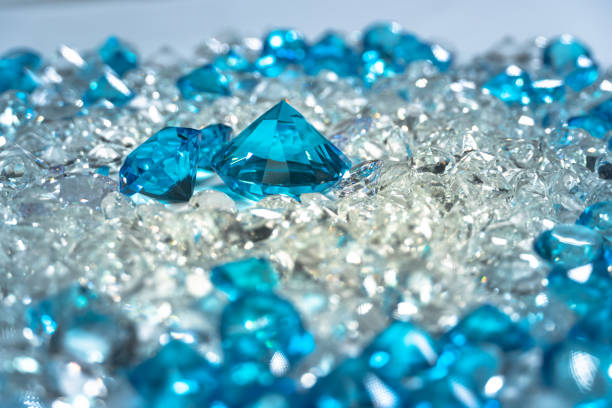 A group of aquamarine blue diamonds arranged in the middle of white diamonds on a white background.\