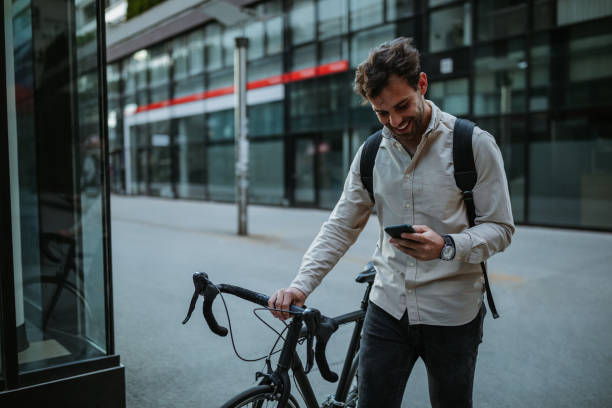 istock Happy cyclist in the city using phone 1320525220