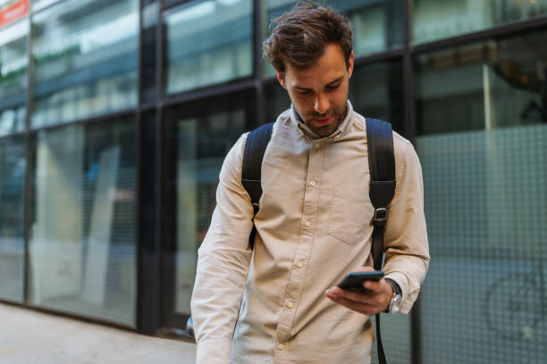 istock Man using phone while going to work with his bike next to him 1320525224