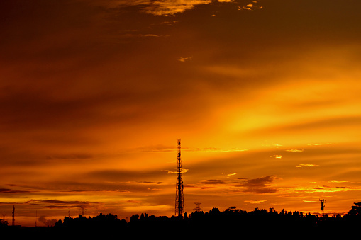 Silhouette of the cellular tower with the sunset scene background