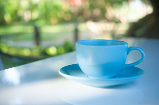 istock Blue coffee cup on white table and natural background 1320529737