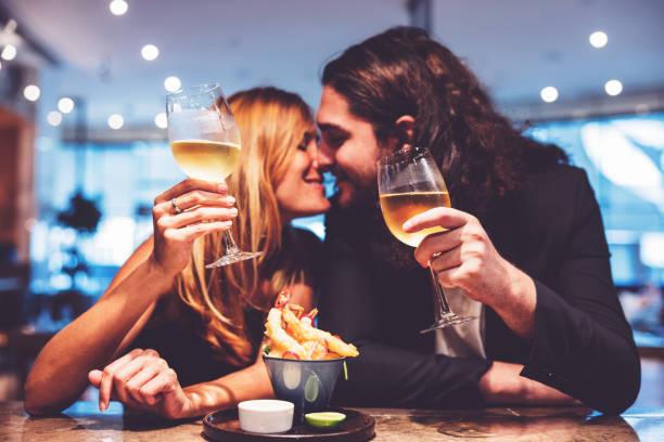 casal curtindo bebidas em um pós-trabalho de pub - drinking couple bar counter bar - fotografias e filmes do acervo