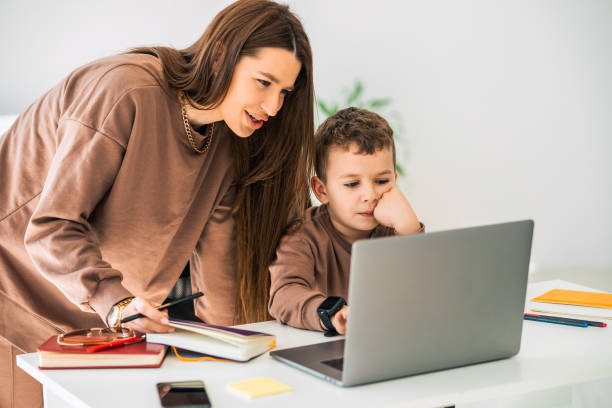 istock Mother helps her son with online distance education 1320532615