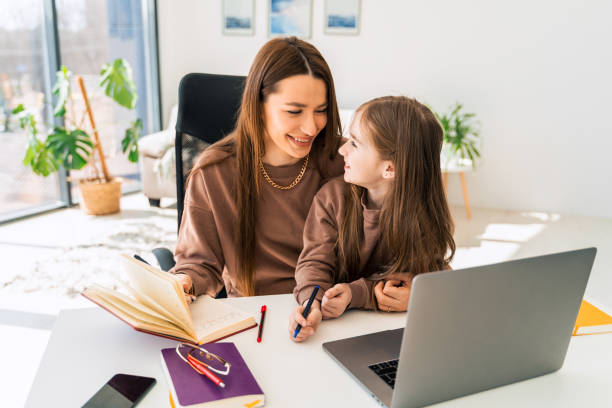 istock Mother and daughter doing homework at the laptop 1320533326