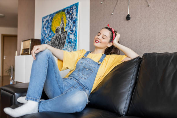 istock Relaxed serene young woman lounge on comfortable sofa at cozy home 1320534527