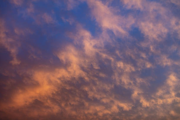 istock Sunbeams through colorful clouds on blue sky background. 1320536515