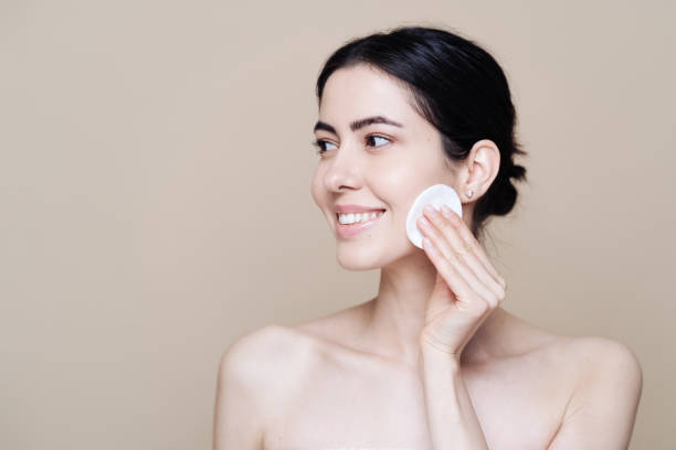 istock Young brunette woman removing makeup from her face 1320536826
