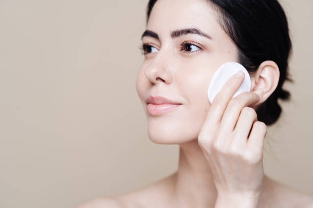 istock Young brunette woman removing makeup from her face 1320536861