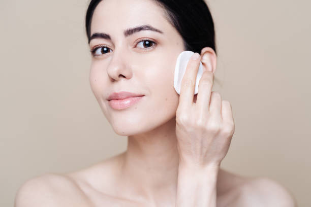 istock Young brunette woman removing makeup from her face 1320536864