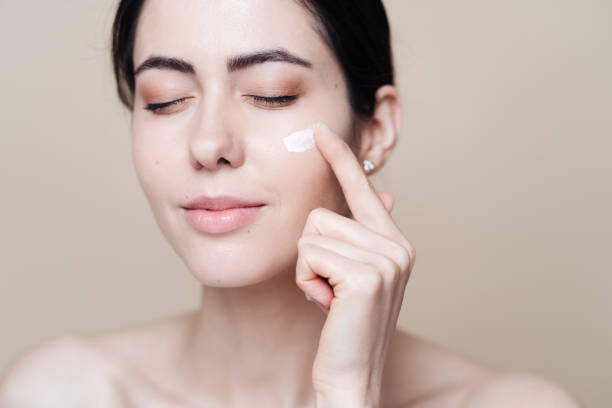 istock Beautiful Caucasian woman applying cream on face 1320537480