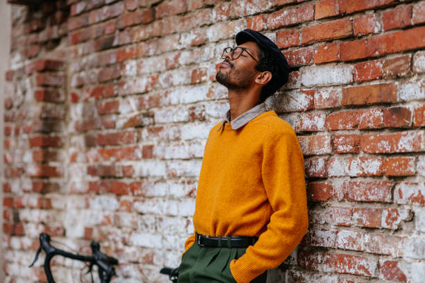 istock Man taking a quick break after bike ride and leaning on brick wall 1320537554