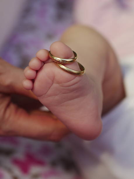 istock Baby's foot with parents wedding rings 1320537746