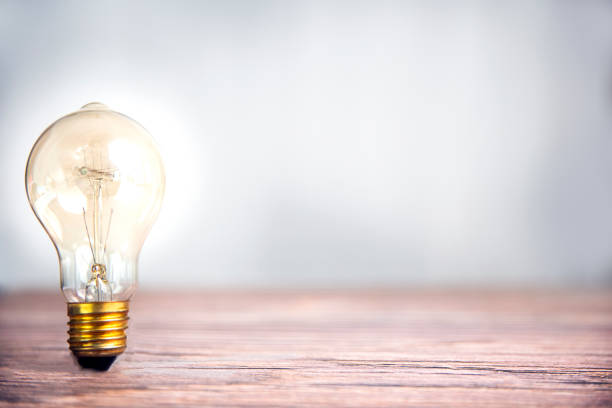 Lightbulb shining on wooden shelf with copy space, idea and creative concept background, dea and Creative concept for startup new project. Technology object and Electrical part theme. Energy and Power saving theme. modern bombilla que brilla en el estante de madera con espacio de copia, idea y fondo de concepto creativo, dea y concepto creativo para la puesta en marcha de un nuevo proyecto. objeto de la tecnología y tema de la parte eléctrica. tema energía y ahorro de en