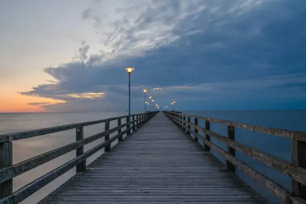 View of the long wooden footbridge and the sea on the pier in the Baltic Sea resort of Ahlbeck on Usedom at dawn.