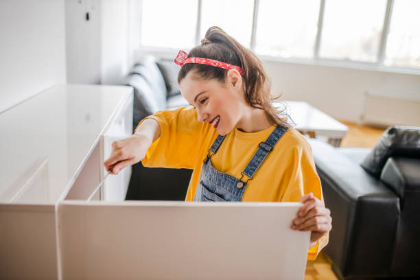 istock Woman is assembling furniture at home 1320542161