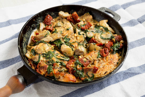 istock Homemade Creamy Tuscan Chicken in a cast-iron pan, low angle view. 1320543461