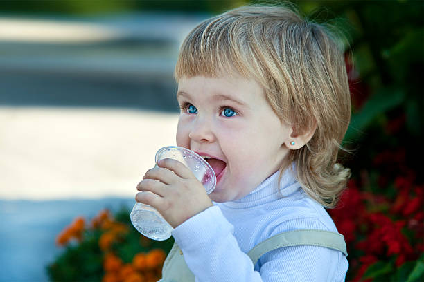 istock baby girl drinks water 132055032
