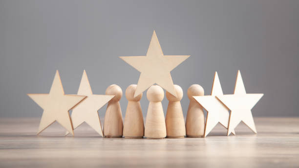 istock Wooden human figures with stars. Best customer evaluation and satisfaction 1320550369