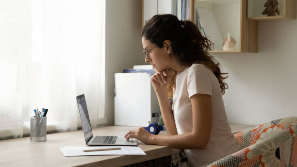 현대 홈 오피스에서 컴퓨터에서 일하는 집중 된 젊은 여성. - computer monitor internet editor education 뉴스 사진 이미지