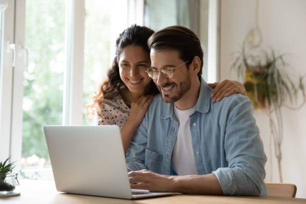 istock Smiling sincere married couple web surfing information online. 1320551777
