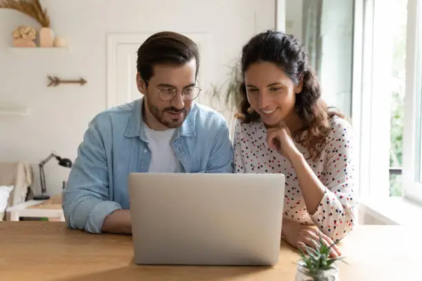 Photo of Happy bonding family couple using computer at home.